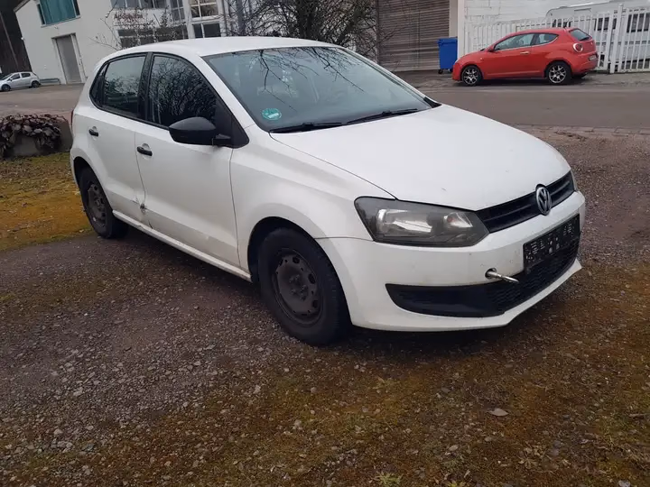 Volkswagen Polo Trendline in Candy-Weiß, Frontansicht schräg von rechts mit sichtbarem Flankenschaden